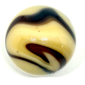 May include: A spherical glass marble featuring a smooth, polished surface with swirling patterns of cream, beige, and deep dark brown colors. The translucent glass displays fluid, organic bands that wrap around the orb, creating a continuous marbled effect throughout the entire object.