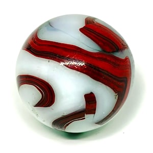 May include: A spherical glass marble featuring a translucent white base with swirling, opaque dark red ribbons and streaks throughout the surface. The object has a smooth, polished finish with a reflective quality and a rounded shape.