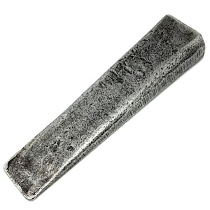 Könnte beinhalten: Ein rechteckiger Metallstab mit einer verwitterten, dunkel silbernen Oberfläche und einer stark texturierten, narbigen Struktur. Das Objekt hat eine konische Form mit abgerundeten Kanten und ein mattes, unebenes Aussehen mit Oxidationsspuren.