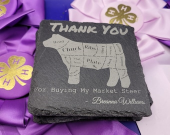 May include: A black slate coaster with the text "Thank You" and a diagram of a cow showing the different cuts of meat. The text "For Buying My Market Steer - Breanna Williams" is also on the coaster.