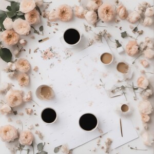 May include: A white surface featuring several cups of black and light brown coffee, scattered pale peach-coloured roses, and green leaves. A small paintbrush and a piece of paper with a floral illustration are placed among the flowers.
