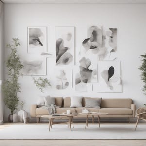 May include: A beige sofa with gray pillows sits in front of a wall featuring a gallery of abstract black and white ink wash paintings. Two wooden coffee tables are placed in front of the sofa, with a wooden armchair and potted plants nearby.