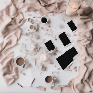 May include: A flat lay arrangement featuring three white coffee cups with brown liquid, three black-screen smartphones, a tablet with a black screen, two lit candles in glass holders, and scattered light pink flower petals on a white surface.