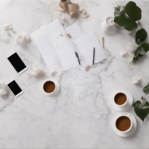 May include: A white marble surface featuring three cups of coffee on saucers, two smartphones with black screens, several sheets of white paper, two black pens, a gold pen, and a green leafy branch with scattered white cotton-like tufts.