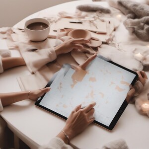 Puede incluir: Una tableta grande con marco negro que muestra una interfaz digital clara con formas abstractas en tonos melocot&oacute;n. El dispositivo es sostenido por manos que usan un l&aacute;piz &oacute;ptico blanco, sobre una superficie blanca junto a una taza y tela.