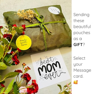 May include: A wrapped package tied with green ribbon and adorned with dried flowers and a yellow sticker that reads "made with love." A card with the text "best MOM ever" is also visible. The package is a gift.