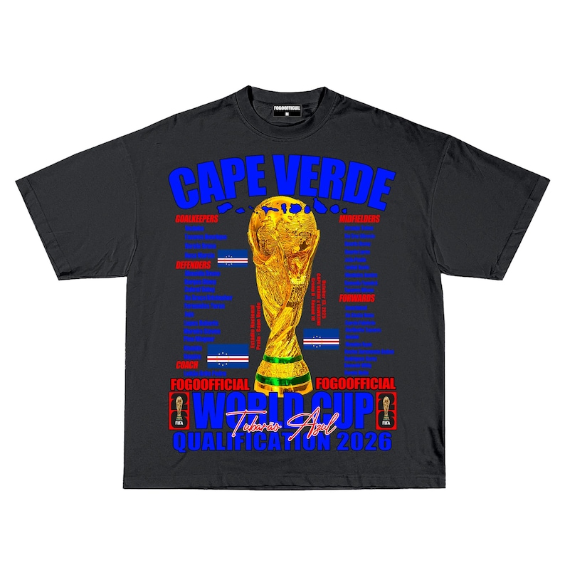 May include: Black t-shirt with a gold trophy graphic and the text "CAPE VERDE" in blue. The shirt also features the text "WORLD CUP" and "QUALIFICATION 2026". The shirt has a crew neck and short sleeves.