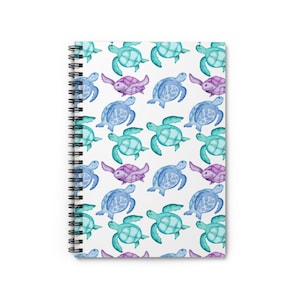 Puede incluir: Una libreta espiral blanca con un patrón repetitivo de tortugas marinas de acuarela en tonos azules, verdes y morados.