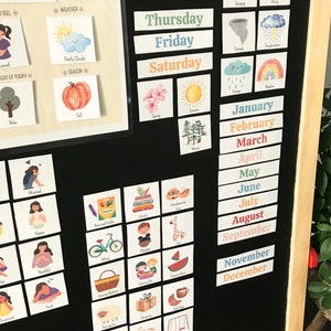 May include: A black dry-erase board with colourful magnetic cards. The cards feature images and text related to days of the week, weather, seasons, emotions, and months of the year. The text on the cards includes "Thursday", "Friday", "Saturday", "January", "February", "March", "April", "May", "June", "July", "August", "September", "November", "December", "Today I Feel", "Weather", "Partly Cloudy", "Season", "Highlight of Today", "Loved", "Tree", "Sad", "Worried", "Angry", "Happy", "Lonely", "Thankful", "Surprised", "Tired", "Arts and Crafts", "Library", "Playtime", "Swing", "Water", "Pumpkin", "Fall", "Spring", "Summer", "Snowing", "Wind", "Thunderstorm", "Rainy", "Rainbow".