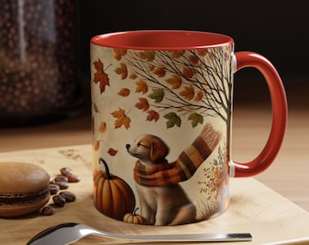May include: A red and white ceramic coffee mug with a fall-themed design. The mug features a dog wearing a scarf, a pumpkin, and falling leaves.
