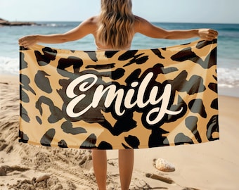 May include: A brown and black leopard print beach towel with the name "Emily" written in white cursive font.