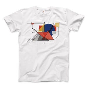 Op de afbeelding: Wit T-shirt met een geometrisch ontwerp in rood, blauw, geel en grijs. Het ontwerp bevat het woord "Bauhaus" in zwarte tekst.
