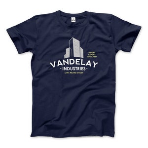 Könnte beinhalten: Marineblaues T-Shirt mit einer weißen Grafik eines Gebäudes und dem Text "Vandelay Industries. Import Export Since 1991. Latex Related Goods."