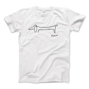 Puede incluir: Camiseta blanca con un dibujo de línea negra de un dachshund de Pablo Picasso. La firma "Picasso" está debajo del dibujo.