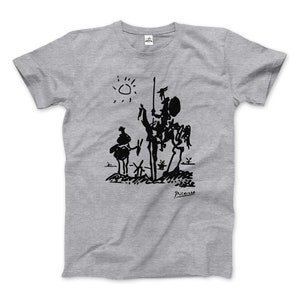 Puede incluir: Una camiseta gris con una ilustración en blanco y negro de un hombre a caballo, una figura más pequeña y un sol. La ilustración está firmada "Picasso".
