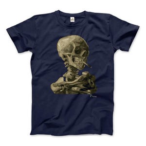 Puede incluir: Una camiseta azul marino con un estampado gráfico de un esqueleto fumando un cigarrillo. El esqueleto está sentado con la cabeza inclinada hacia un lado. El gráfico está en un estilo vintage, que recuerda a una pintura. El texto "Vincent" está impreso debajo del gráfico.