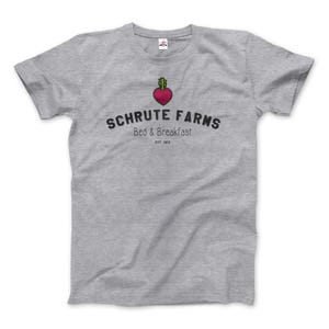 Puede incluir: Camiseta gris con un gráfico en blanco y negro de una remolacha y el texto "Schrute Farms Bed & Breakfast Est. 1912"