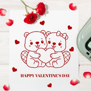 Puede incluir: Una tarjeta blanca con una ilustraci&oacute;n roja de dos castores de dibujos animados sosteniendo un coraz&oacute;n, con el texto "HAPPY VALENTINE'S DAY". Corazones rojos y p&eacute;talos de rosa rodean la tarjeta.