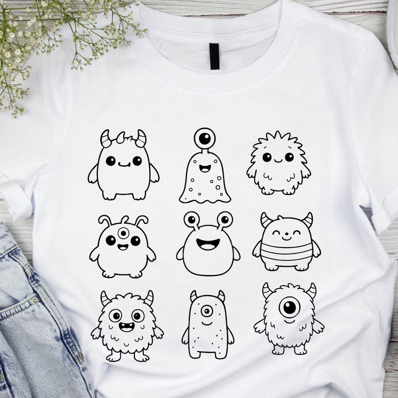 May include: White t-shirt featuring a collection of nine cartoon monsters in black outline. Each monster has a unique design, including different shapes, eyes, and horns. The shirt is made of a soft, comfortable material.