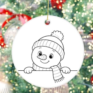 May include: A white, round Christmas ornament featuring a black and white illustration of a snowman. The snowman wears a knit hat, scarf, and has a carrot nose. The ornament is hanging by a gold string.