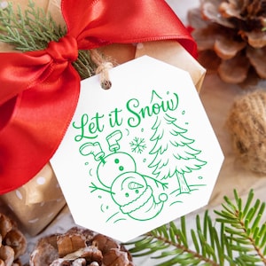 May include: A wrapped gift with a red ribbon and a white tag. The tag features a green illustration of a snowman, Christmas tree, and the words "Let it Snow". Pine cones and greenery are in the background.