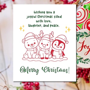 May include: A white Christmas card with a red and green illustration of a bear, reindeer, and penguin wearing scarves and Santa hats. The card has the text "Wishing you a joyful Christmas filled with love, laughter, and peace." and "Merry Christmas!"