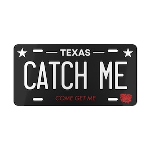 May include: Black Texas license plate with white text that reads "CATCH ME" above "COME GET ME". The word "TEXAS" is at the top. Two white stars are on each side.