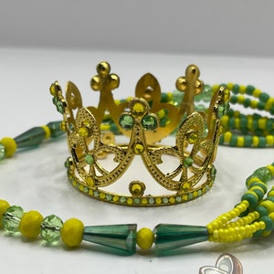 May include: A gold crown with green and yellow rhinestones, and a green and yellow beaded necklace.