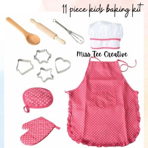 Könnte beinhalten: Ein 11-teiliges Backset für Kinder mit einer rosa-weiß gepunkteten Schürze, einer weißen Kochmütze, zwei rosa Ofenhandschuhen, einem Holzlöffel, einem Nudelholz, einem Schneebesen und vier Metall-Ausstechformen. Miss Tee Creative.