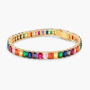 May include: A gold bracelet featuring a rainbow of rectangular gemstones. The bracelet is crafted from gold and has a clasp fastening.
