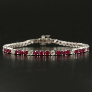 May include: A white gold tennis bracelet with alternating round rubies and diamonds.