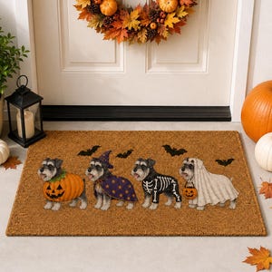 Puede incluir: Un felpudo rectangular de fibra de coco marrón con cuatro perros Schnauzer con disfraces de Halloween. Los perros están vestidos de calabaza, mago con capa morada de estrellas, esqueleto y fantasma sosteniendo un cubo de calabaza.