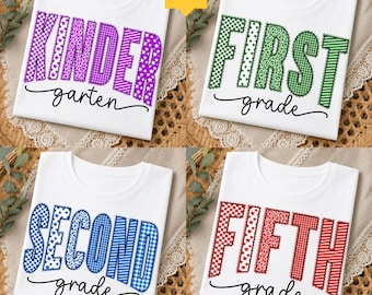 May include: Four white t-shirts featuring school grade text designs. The top left shirt says KINDER garten in purple, top right says FIRST grade in green, bottom left says SECOND grade in blue, and bottom right says FIFTH grade in red.