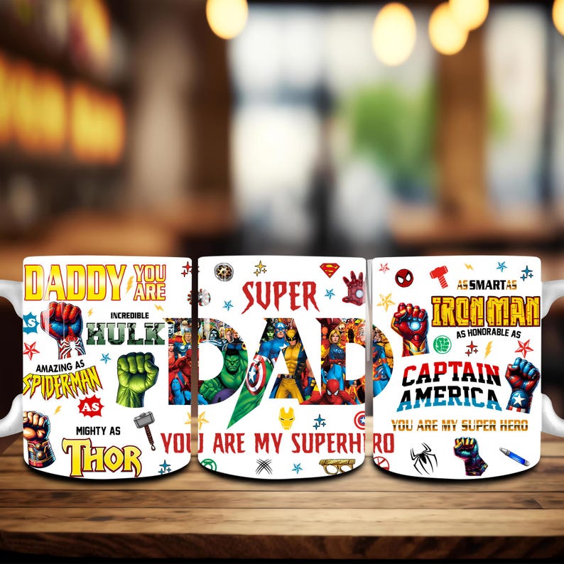 May include: Three white ceramic mugs with superhero-themed designs. One mug says "Daddy, You Are" with superhero graphics. The second mug says "Super Dad, You Are My Superhero." The third mug says "Iron Man, Captain America, You Are My Super Hero."