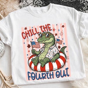 Könnte beinhalten: Weißes T-Shirt mit einem Cartoon-Alligator, der eine Sonnenbrille in Sternform und ein Hawaiihemd trägt und auf einem rot-weiß gestreiften Schwimmring entspannt. Der Text "Chill the Fourth Out" ist abgebildet.