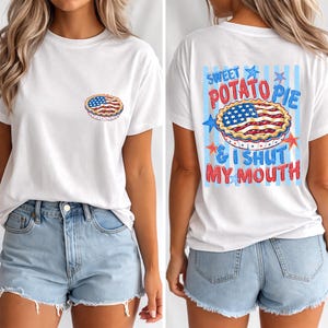 May include: A white t-shirt featuring a small graphic of a pie with an American flag pattern on the front left chest. The back displays a large graphic of the same pie with the text SWEET POTATO PIE & I SHUT MY MOUTH and blue stripes.