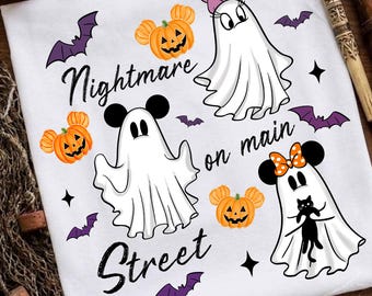 May include: A white t-shirt featuring a graphic print of three white ghosts, orange pumpkins with mouse-like ears, and purple bats. The text reads Nightmare on main Street in black script. The design includes a ghost with a pink bow and a ghost holding a black cat.