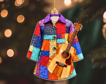 May include: A flat, hanging ornament shaped like a long-sleeved coat with a vibrant, multi-colored patchwork pattern in shades of red, blue, orange, and purple, featuring a light-colored acoustic guitar layered over the front of the garment.