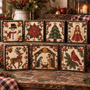 May include: A set of seven square wooden blocks featuring holiday-themed illustrations including a snowman, a poinsettia, a Christmas tree, an angel, a reindeer, a nativity scene, and a cardinal, all framed by a geometric quilt-like border.