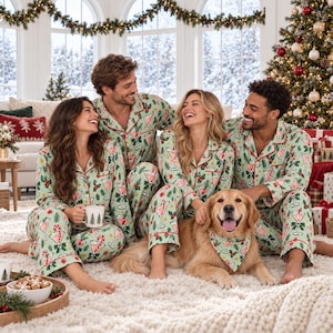 May include: Light green long-sleeve button-down pajama sets featuring a repeating pattern of martini glasses, candy canes, and holly leaves with red piping trim. A golden retriever wears a matching triangular bandana with the same print.