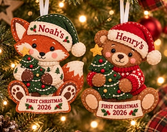May include: Two felt Christmas ornaments featuring a fox and a bear. The fox wears a green hat with 'Noah's' and a sweater, holding a tree. The bear wears a red hat with 'Henry's' and a red sweater, holding a tree. Both have 'FIRST CHRISTMAS 2026'.