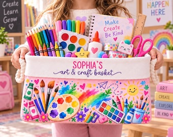 May include: A rectangular fabric storage basket with rope handles, featuring the text 'SOPHIA'S art & craft basket' and colorful illustrations of art supplies. The basket is filled with colored pencils, markers, a watercolor set, a notebook, and scissors.