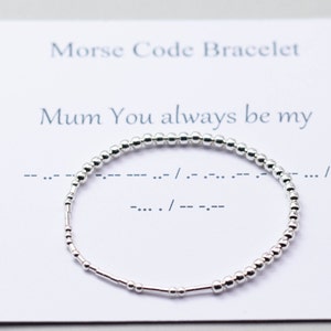 Può includere: Braccialetto d'argento con perline che compongono la frase "Mum You always be my" in codice Morse. Il braccialetto è su una carta bianca con il testo "Morse Code Bracelet" e "Mum You always be my" scritto su di essa.