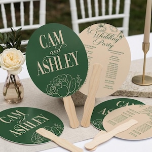 May include: Round hand fans with wooden handles featuring dark green and cream colors. The green fans display the text CAM and ASHLEY with floral line art. The cream fans show the text Wedding Party with a list of roles and floral illustrations.