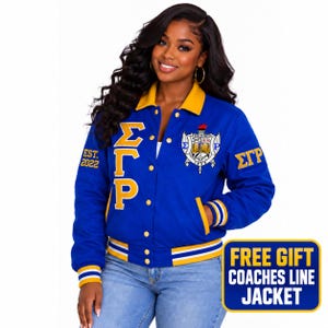 May include: A royal blue varsity jacket with a yellow collar, cuffs, and hem featuring white and yellow stripes. The jacket displays the Greek letters ΣΓΡ in yellow, the text EST. 2022, and a detailed crest emblem on the chest with the text FOUNDED 1922.