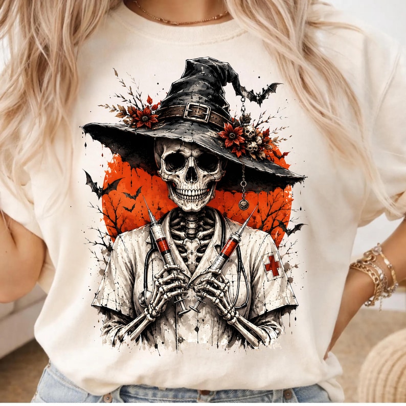 May include: A cream-colored t-shirt featuring a graphic of a skeleton dressed as a nurse, wearing a witch hat adorned with red flowers and a skull. The skeleton holds two syringes, set against a large orange moon with silhouettes of bats and trees.
