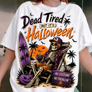 May include: A white t-shirt featuring a graphic of a skeleton wearing sunglasses and a floral shirt, relaxing in a beach chair with a surfboard and a pumpkin. The text reads Dead Tired BUT IT'S Halloween and NO COSTUME NO PROBLEM with a skull icon.