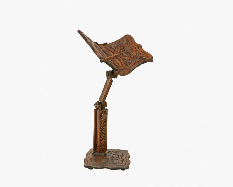 May include: A wooden book stand with intricate carvings. The stand is adjustable and has a base with a decorative design.