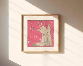 May include: A framed print featuring a whimsical illustration of a fluffy white cat reaching for colorful bubbles against a pink background. The artwork is set in a light wood frame, creating a charming and playful aesthetic.