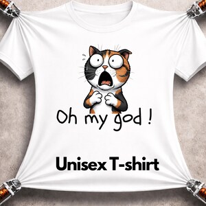 May include: White unisex t-shirt featuring a cartoon cat with a surprised expression. The cat is black, orange, and white, with wide eyes and an open mouth. The text "Oh my god!" and "Unisex T-shirt" are printed below the cat.